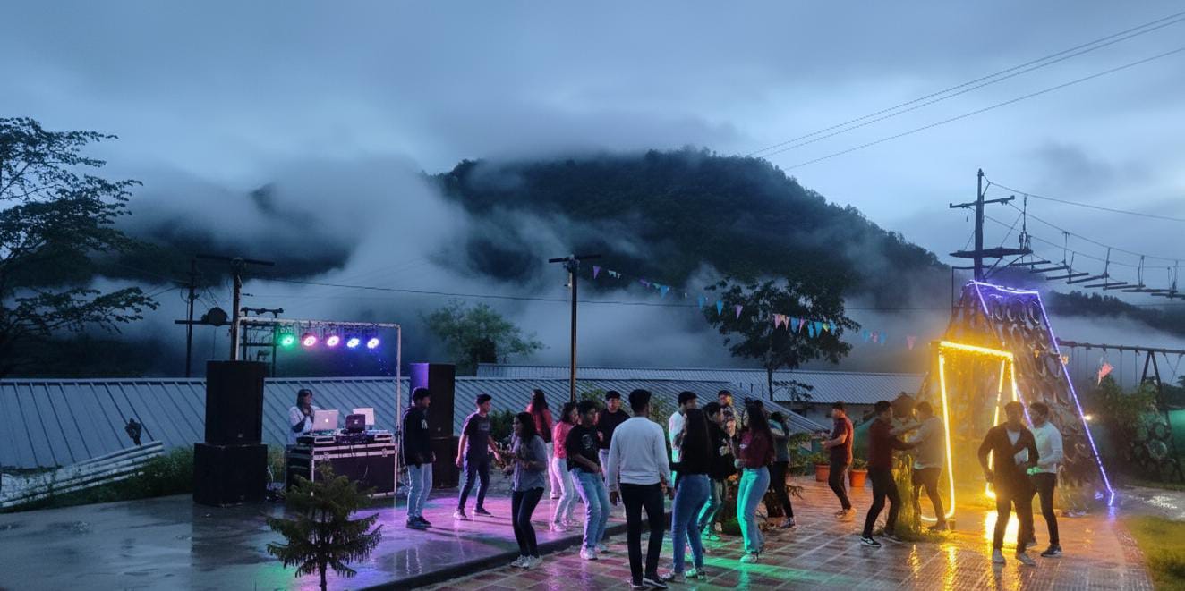 Corporate team enjoying a DJ party surrounded by nature's mist and fog at The Jungle Mist Resort