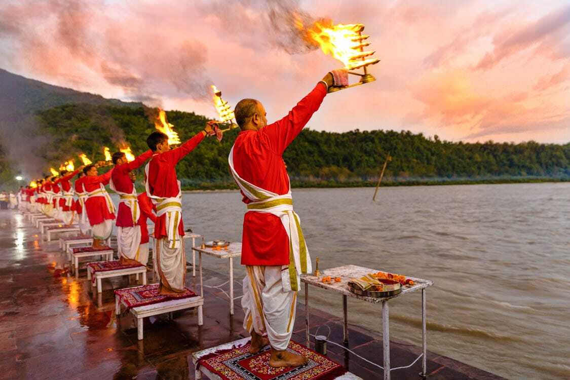 Evening Ganga Aarti ceremony at Triveni Ghat with priests performing rituals on Maa Ganga river