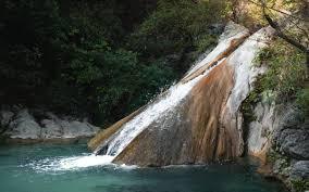 Patna Waterfall cascading through lush green forests near The Jungle Mist Resort Rishikesh
